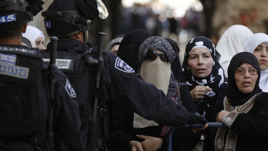 Israeli policemen prevent Palestinian women from entering the compound which houses al-Aqsa mosque and is known to Muslims as Noble Sanctuary and to Jews as Temple Mount, in Jerusalem's Old City April 16, 2014. Israeli riot police entered one of Jerusalem's most revered and politically sensitive religious compounds on Wednesday to disperse rock-throwing Palestinians opposed to any Jewish attempts to pray there. REUTERS/Ammar Awad (JERUSALEM - Tags: POLITICS CIVIL UNREST RELIGION) - RTR3LHFX
