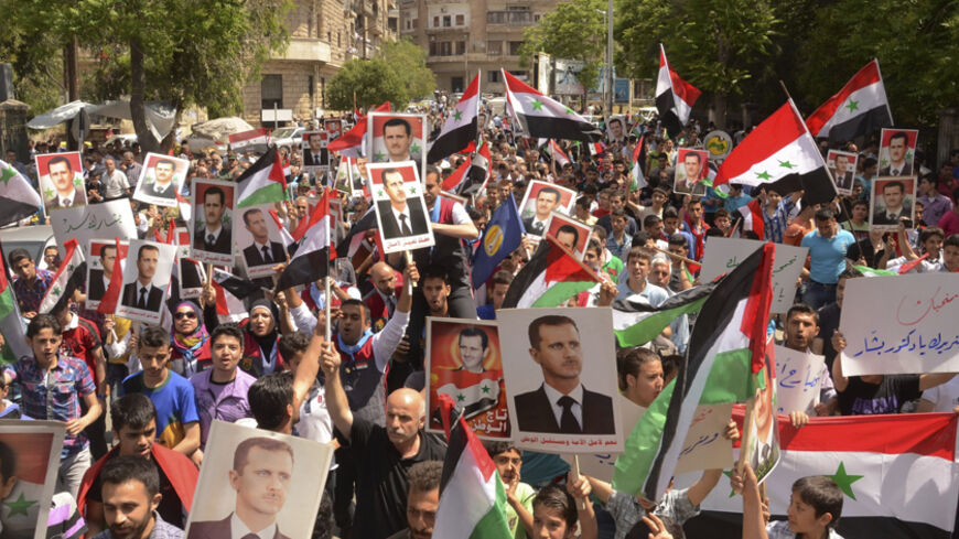 Supporters of Syria's President Bashar al-Assad take part in a rally showing support a day after he declared that he would seek re-election in June, in Aleppo April 29, 2014. Al-Assad declared on Monday he will seek re-election in June, defying calls from his opponents to step aside and allow a political solution to the devastating civil war stemming from protests against his rule. REUTERS/George Ourfalian (SYRIA - Tags: POLITICS ELECTIONS) - RTR3N3ED