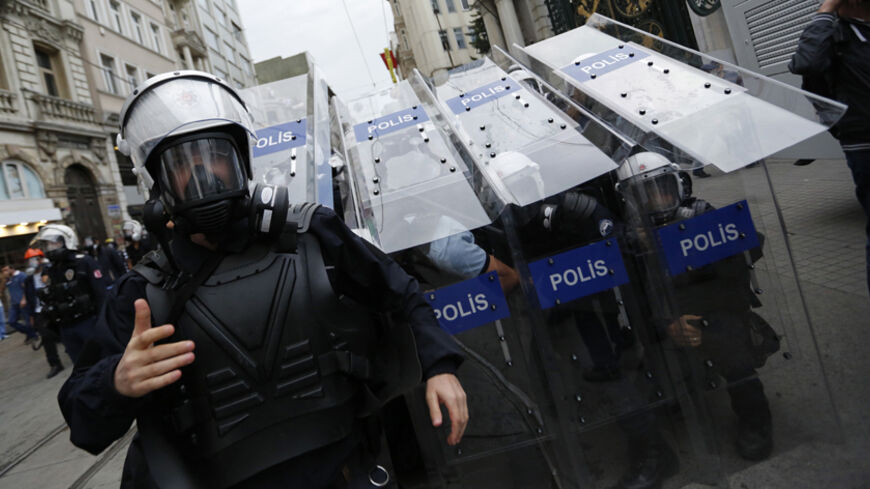 Turkish riot police use their shields to protect themselves as they clash with demonstrators during a protest in central Istanbul May 31, 2014. On the first anniversary of nationwide protests that shook Prime Minster Tayyip Erdogan's rule, barely a thousand anti-government demonstrators marched in Istanbul on Saturday. Outnumbered by riot police, they were soon sent scurrying into side streets by tear gas and water cannon. Their scant numbers were an illustration of Erdogan's tightening grip on power despit