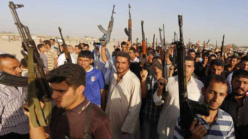 Volunteers, who have joined the Iraqi Army to fight against predominantly Sunni militants from the radical Islamic State of Iraq and the Levant (ISIL), carry weapons during a parade in the streets in Al-Fdhiliya district, eastern Baghdad June 15, 2014. The insurgent offensive that has threatened to dismember Iraq spread to the northwest of the country on Sunday, when Sunni militants launched a dawn raid on a town close to the Syrian border, clashing with police and government forces.  REUTERS/Thaier Al-Suda