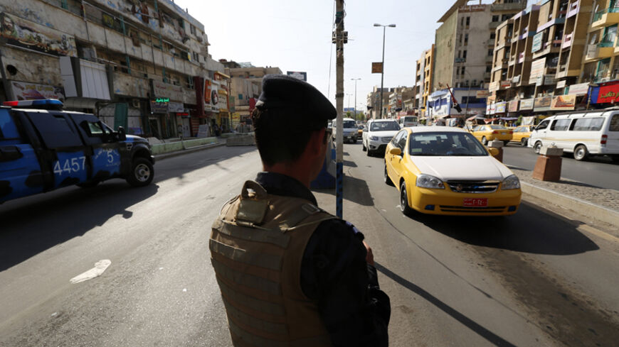 A member of the Iraqi security forces stands guard at a checkpoint during an intensive security deployment in Baghdad, June 16, 2014. The United States is contemplating talks with its arch-enemy Iran to support the Iraqi government in its battle with Sunni Islamist insurgents who routed Baghdad's army and seized the north of the country in the past week.  REUTERS/Thaier Al-Sudani  (IRAQ - Tags: CIVIL UNREST POLITICS MILITARY CONFLICT) - RTR3U2D3