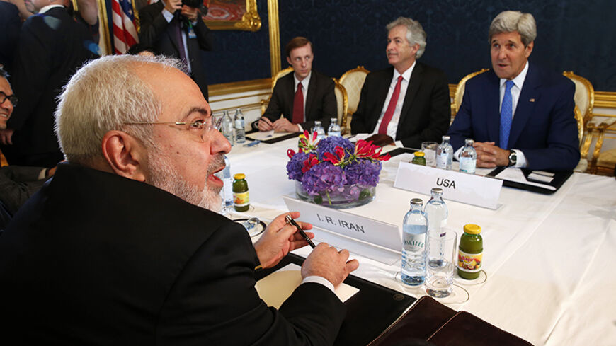 Iran's Foreign Minister Javad Zarif (L) holds a bilateral meeting with U.S. Secretary of State John Kerry (R) on the second straight day of talks over Tehran's nuclear program in Vienna, July 14, 2014. Kerry will press his Iranian counterpart Zarif to make "critical choices" in a second straight day of talks over Tehran's nuclear program on Monday, a U.S. official said. REUTERS/Jim Bourg  (AUSTRIA - Tags: POLITICS ENERGY) - RTR3YJOW