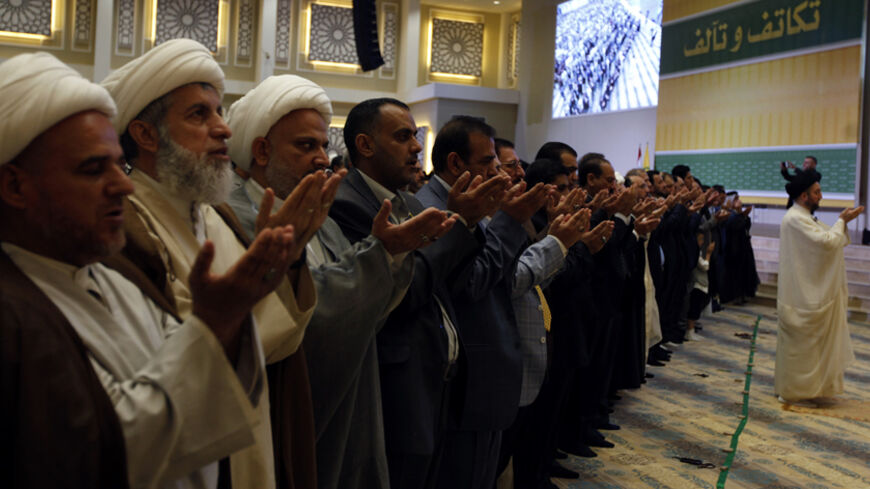 Shi'ite Muslims attend prayers for Eid al-Fitr as they mark the end of the fasting month of Ramadan at the headquarters of Shi'ite cleric Ammar al-Hakim, the leader of the Islamic Supreme Council of Iraq (ISCI), in Baghdad July 29, 2014.      REUTERS/Ahmed Saad (IRAQ - Tags: SOCIETY RELIGION) - RTR40GYT