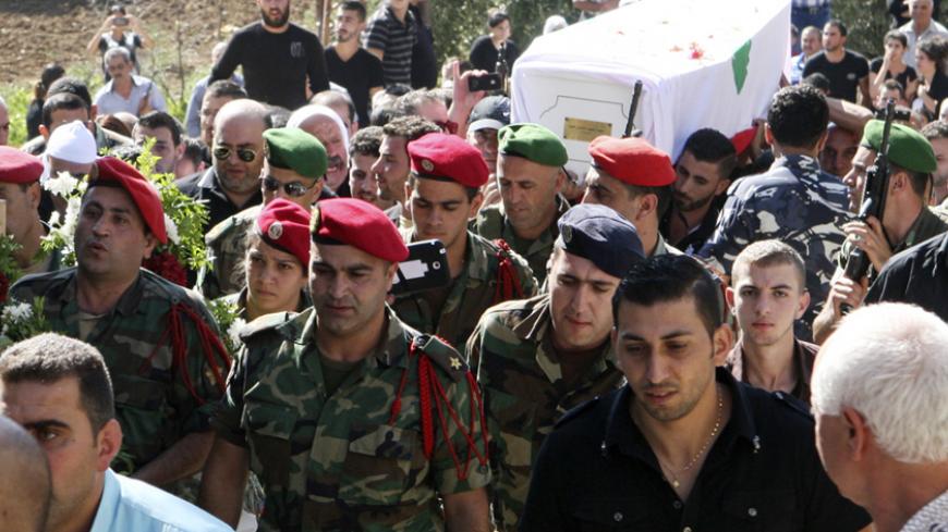 Lebanese Army soldiers and relatives of Druze soldier Khaldoon Raouf Hamoud carry his coffin during his funeral in Akbeh, Rashaya August 3, 2014. Lebanese soldiers traded fire with Islamist gunmen and shelled areas around the border town of Arsal on Sunday in a push to dislodge the biggest incursion by militants into Lebanon since Syria's civil war began. At least 10 Lebanese soldiers have died in the fighting, which erupted after Islamist gunmen seized a local police station on Saturday in response to the 