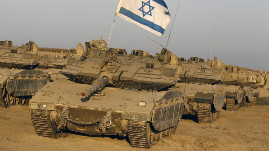 Israeli tanks are seen in a staging area near the border with the Gaza Strip August 7, 2014. Mediators worked against the clock on Thursday to extend a Gaza truce between Israel and the Palestinians as the three-day ceasefire went into its final 24 hours. Israel has said it is ready to agree to an extension as Egyptian mediators pursued talks with Israelis and Palestinians on an enduring end to a war that devastated the Hamas-ruled enclave, while Palestinians want an Israeli-Egyptian blockade of Gaza to be 