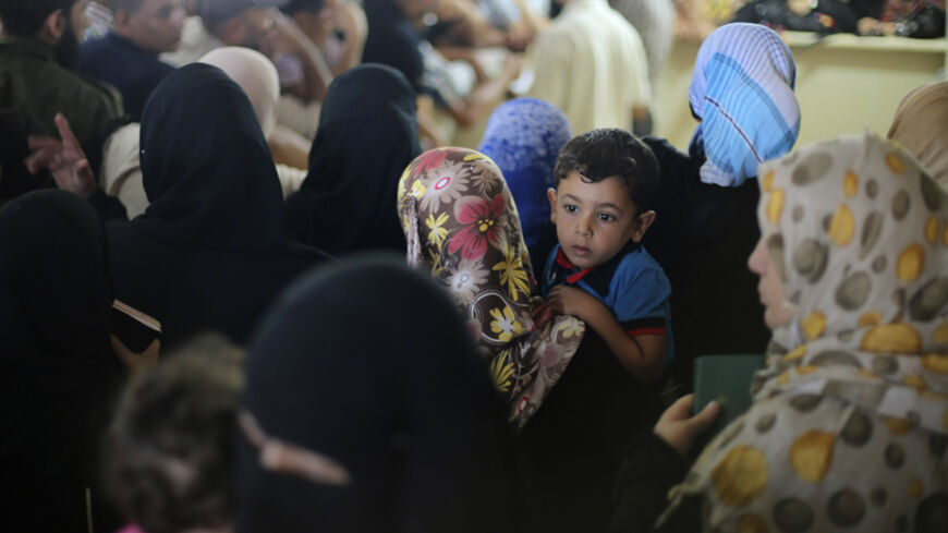 A Palestinian boy, hoping to cross into Egypt with his family, is held by his mother as they wait at the Rafah crossing between Egypt and the southern Gaza Strip August 12, 2014. Under Egyptian President Abdel Fattah al-Sisi, Cairo has secured closures on the Gaza border, increasing economic pressure on Hamas from a long-running Israeli blockade. Talks to end a month-long war between Israel and Islamist militants in Gaza have made no progress so far, an Israeli official said on Tuesday, as a 72-hour ceasefi