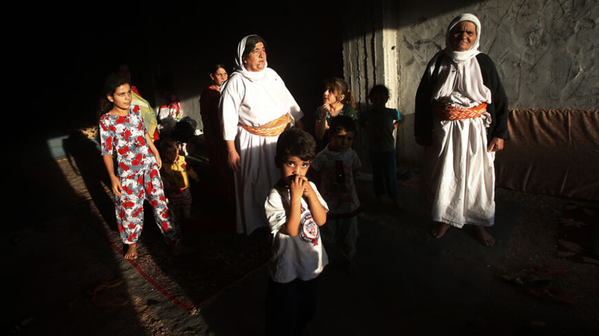 Displaced people from the minority Yazidi sect who fled the violence in the Iraqi town of Sinjar, wait for aid at an abandoned building that they are using as their main residence, outside the city of Dohuk August 25, 2014. REUTERS/Youssef Boudlal (IRAQ - Tags: CIVIL UNREST POLITICS TPX IMAGES OF THE DAY) - RTR43P9T