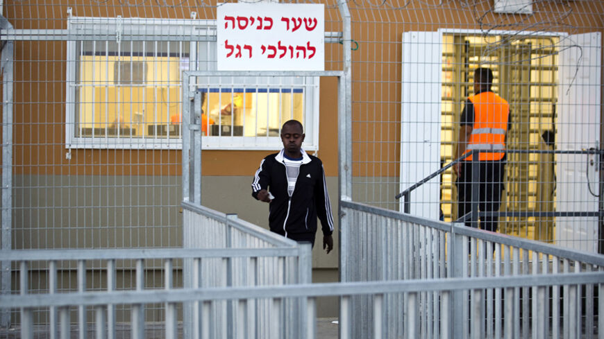 An African migrant walks outside the Holot open detention centre in Israel's southern Negev desert September 22, 2014. Israel's high court on Monday outlawed a detention centre where African migrants are held without trial and ordered some 2,000 inmates there released over the next three months. REUTERS/ Amir Cohen (ISRAEL - Tags: POLITICS SOCIETY IMMIGRATION) - RTR47A6X