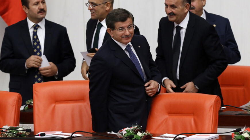 Turkey's Prime Minister Ahmet Davutoglu (C) attends a debate marking the reconvene of the parliament after a summer recess at the Turkish Parliament in Ankara October 1, 2014. REUTERS/Umit Bektas (TURKEY - Tags: POLITICS) - RTR48IO6