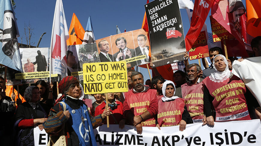 Protesters demonstrate in front of the Turkish Parliament in Ankara October 2, 2014.  The protest was held hours before a debate for MPs to vote on a motion, which would allow the government to authorise cross-border military incursions against Islamic State fighters in Syria and Iraq, and allow coalition forces to use Turkish territory. The placard (in black) reads, "Occupiers always lose." The shirts read (from L-R), "We are demonstrating against barbarism" and "We are on a hunger strike for the safety of