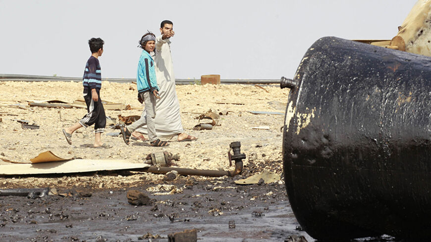 People inspect damage at an oil refinery that was targeted by what activists said were U.S.-led air strikes at al-Khaboura village, near the Syrian town of Tel Abyad of Raqqa governate October 2, 2014. Air strikes believed to have been carried out by U.S.-led forces hit three makeshift oil refineries in Syria's Raqqa province early on Sunday as part of an assault to weaken Islamic State (IS) militants, a human rights group said. The United States has been carrying out strikes in Iraq against the Islamic Sta
