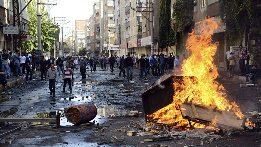 Kurdish protesters set fire to a barricade set up to block the street as they clash with riot police in Diyarbakir October 7, 2014.  At least 12 people died on Tuesday during violent clashes across Turkey, local media reported, as the fate of the besieged Syrian border town of Kobani stirred up decades of tensions with Turkey's Kurdish minority. Violence erupted in Turkish towns and cities mainly in the Kurdish southeastern provinces, as protesters took to the streets to demand the government do more to pro