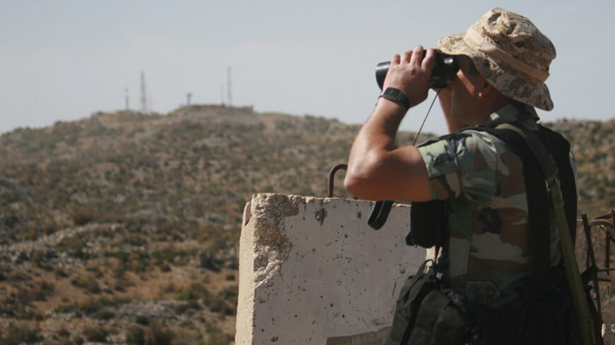 A Lebanese soldier uses a pair of binoculars in the Shebaa area of southern Lebanon, as he looks towards an Israeli position near the border with Israel October 8, 2014. An attack by Hezbollah on Lebanon's border with Israel which wounded two Israeli soldiers was a message that the group remained ready to confront its old foe despite its engagement in Syria's civil war, the group's deputy leader said. The soldiers were wounded by a bomb planted by Lebanese Hezbollah fighters in the Shebaa hills, drawing Isr