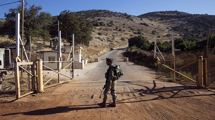 An Israeli soldier stands guard at a check point near the Lebanese-Israeli border, southern Lebanon October 8, 2014. An attack by Hezbollah on Lebanon's border with Israel which wounded two Israeli soldiers was a message that the group remained ready to confront its old foe despite its engagement in Syria's civil war, the group's deputy leader said. The soldiers were wounded by a bomb planted by Lebanese Hezbollah fighters in the Shebaa hills, drawing Israeli artillery fire in response. It was the first tim