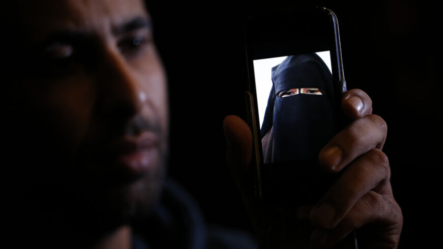 Foad, the brother of 15 year-old Nora who left her home in Avignon for Syria nine months ago, shows a portrait he took last September on his cell phone as he attends an interview with Reuters in Paris, October 6, 2014. Foad, a French truck driver of Moroccan origin, travelled alone through war-torn Syria to rescue his 15-year-old sister from an Islamist group she said was holding her captive. But when they finally stood face to face, in tears, she would not leave. Foad is convinced that his sister Nora, who