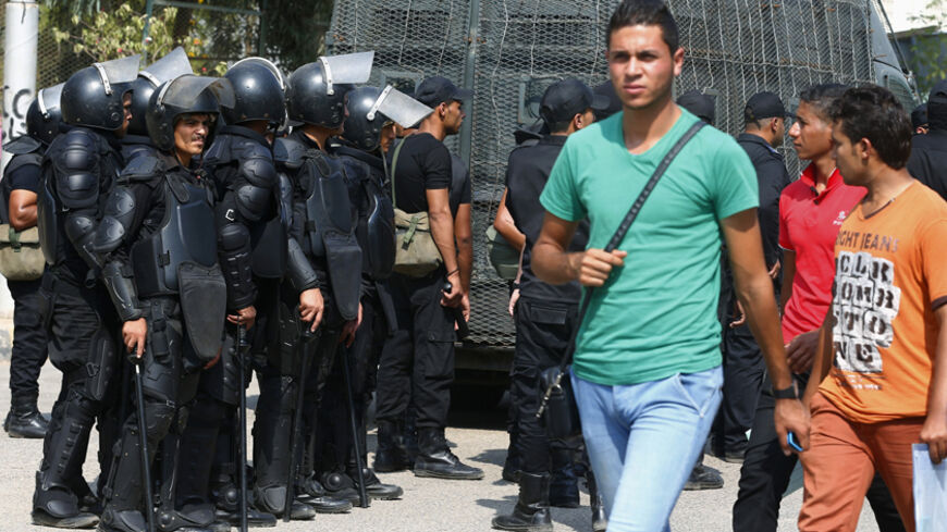 Al-Azhar University students walk past riot police during a protest conducted by a pro-Muslim Brotherhood student movement known as the Students Against the Coup, in Nasr City district October 12, 2014. Universities in Egypt opened on Saturday for the new semester with long queues due to increased security measures such as requiring students to present their identification cards and having their bags inspected, according to local media Al-Ahram's Arabic website.  REUTERS/Amr Abdallah Dalsh (EGYPT - Tags: CI