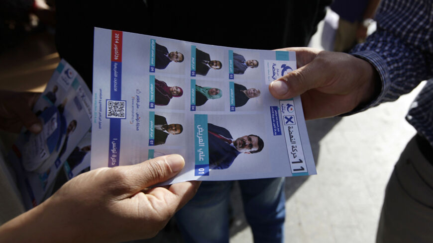 A supporter of the Ennahda Movement party distributes leaflets on the party's candidates for parliamentary elections, in Tunis October 22, 2014. Sunday's parliamentary vote will elect the 217-member assembly, and that will chose a new prime minister to lead the government to replace Tunisia's caretaker administration. Presidential elections will follow next month. REUTERS/Anis Mili (TUNISIA - Tags: POLITICS ELECTIONS) - RTR4B8QR