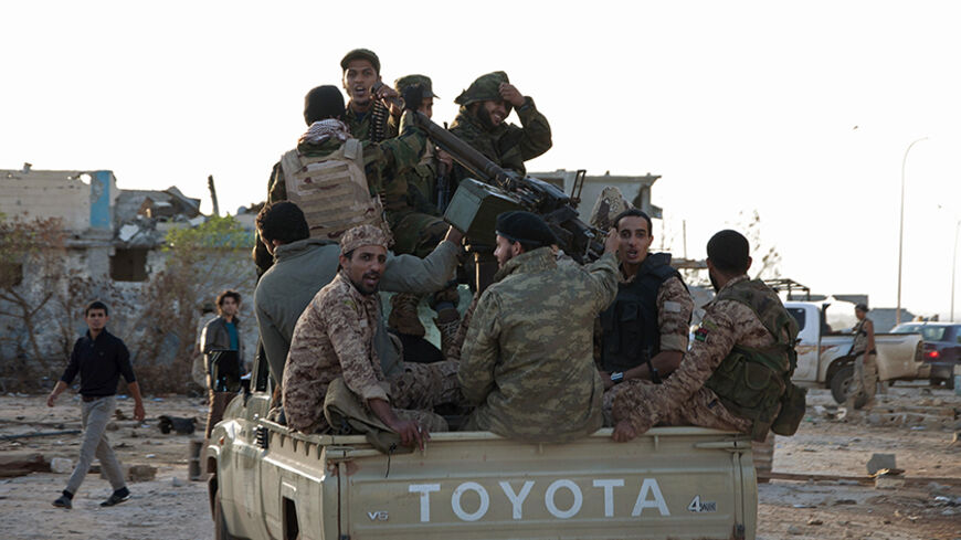 Members of forces loyal to former general Khalifa Haftar ride in a truck in the Benina area, east of Benghazi October 24, 2014. Violent clashes have taken place over the past few weeks between these forces loyal to Haftar and both the Islamist group, the Shura Council of Libyan Revolutionaries, and an alliance of former anti-Gaddafi rebels Ansar al-Sharia, for control of the airport nearby. The two latter groups have now withdrawn and the area is  being controlled by these forces loyal to Haftar. Libya's ar