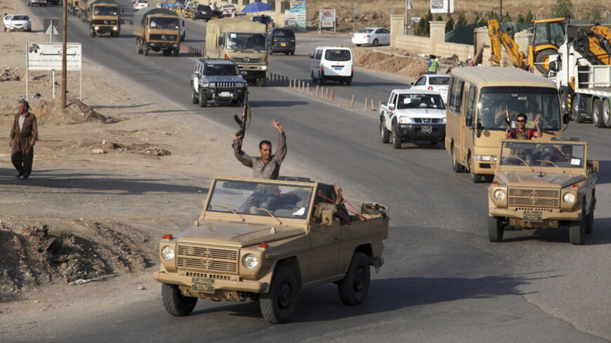 A convoy of Kurdish peshmerga fighters drive through Arbil after leaving a base in northern Iraq, on their way to the Syrian town of Kobani ,October 28, 2014. Iraqi peshmerga fighters left Iraq for the besieged Syrian town of Kobani on Tuesday to help fellow Kurds in their battle against Islamic State militants, a senior Kurdish official said. REUTERS/Azad Lashkari (IRAQ - Tags: CIVIL UNREST POLITICS MILITARY CONFLICT) - RTR4BWKZ