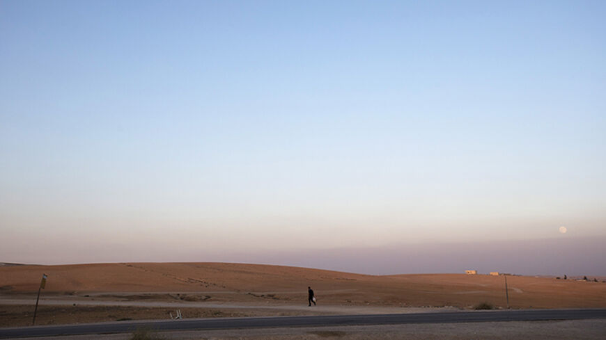 A man walks near the village of al-Sira, one of dozens of ramshackle Bedouin Arab communities in the Negev desert which are not recognised by the Israeli state, in southern Israel August 20, 2013. For decades Arab Bedouins have eked out a meagre existence in the Negev desert, largely under the Israeli government's radar, but now many will have to make way for new developments. Israel has already invested around $5.6 billion to build military bases in the Negev desert and plans to build 10 new communities th
