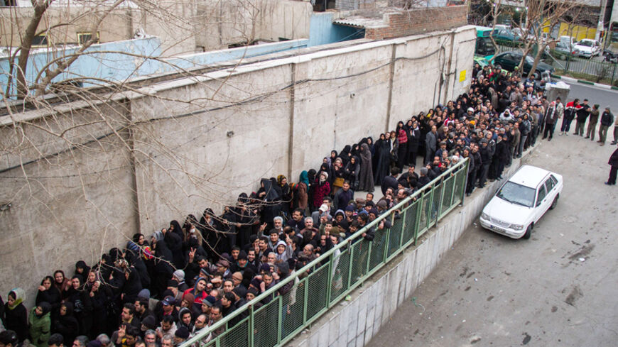 A picture taken on February 3, 2014 shows low-income Iranians lining up to receive food supplies in southern Tehran. Iranian President Hassan Rouhani faced harsh criticism from conservatives today over what they say is a poorly implemented scheme to distribute food to low-income families in the sanctions-hit Islamic republic. The programme aims to hand out packages of frozen chicken, rice, vegetable oil, cheese and eggs to poor families ahead of Iranian New Year celebrations in mid-March.  AFP PHOTO/ISNA/DA
