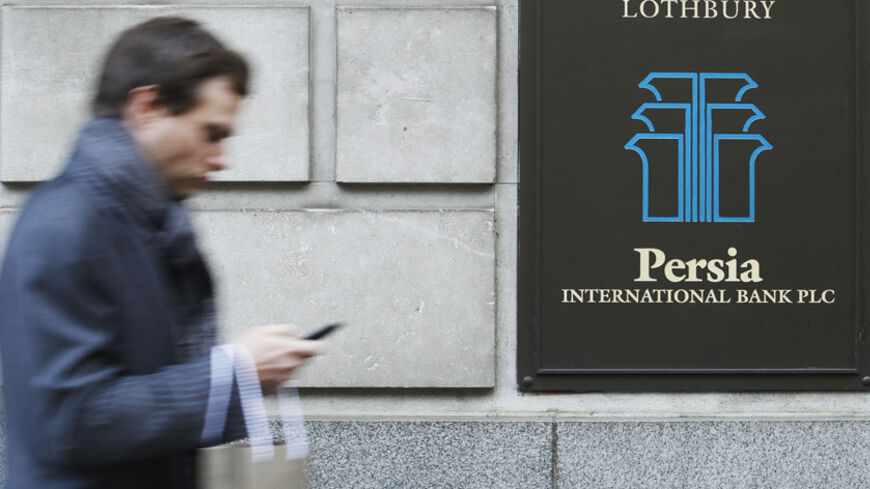 A City worker passes a branch of Iranian owned Persia Bank International in London December 22, 2011. Hit by international sanctions, the Iranian banks in London linger on, unable to take on new business. The pressure on them is rising. Last month, the UK forbid its banks to do any business with Iranian banks after a new report from a nuclear watchdog highlighted further concerns about the possible military dimensions to Iran's nuclear programme.  REUTERS/Luke MacGregor  (BRITAIN - Tags: BUSINESS POLITICS) 