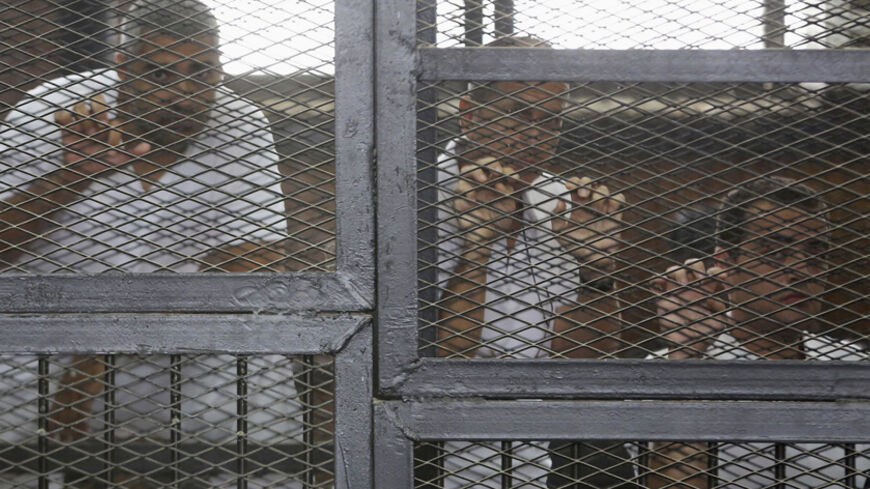 Al Jazeera journalists (L-R) Mohammed Fahmy, Peter Greste and Baher Mohamed stand behind bars at a court in Cairo May 15, 2014. The trial of the three Al Jazeera journalists accused of aiding of a "terrorist organisation" has been postponed to May 22 after the judge on Thursday authorised the defence to examine the evidence being held by the prosecution. The Qatar-based television network's journalists - Peter Greste, an Australian, Mohamed Fahmy, a Canadian-Egyptian national, and Baher Mohamed, an Egyptian