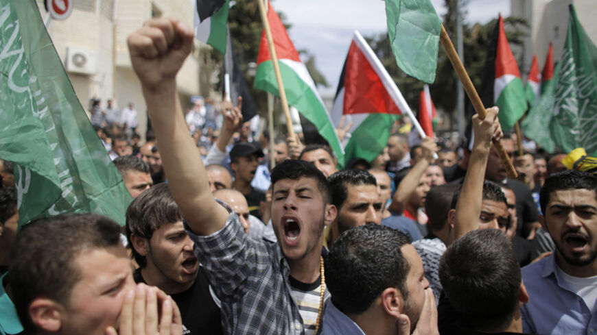 Mourners chant slogans during the funeral of two Palestinians, who were shot dead by Israeli forces on Thursday, in the West Bank city of Ramallah May 16, 2014. Israeli forces shot dead the two Palestinians during a stone-throwing protest on Thursday to mark the "Nakba", or "catastrophe", as Palestinians term their displacement when Israel was founded. REUTERS/Ammar Awad (WEST BANK - Tags: POLITICS) - RTR3PFK8