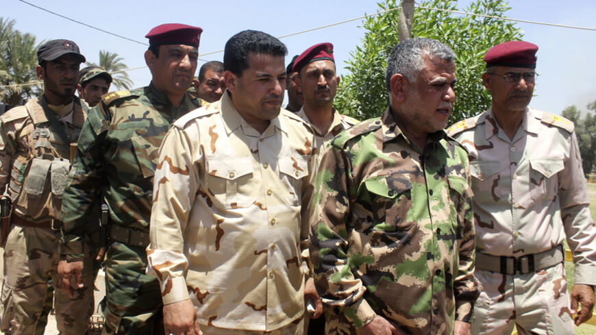 Iraq's transport minister Hadi al-Amiri (2nd R), head of the Badr Organisation, visits members of the Iraqi security forces after clashes with the predominantly Sunni militants from the radical Islamic State of Iraq and the Levant (ISIL) in the town of Dalli Abbas in Diyala province, June 26, 2014. Grand Ayatollah Ali Sistani, the most influential Shi'ite cleric in Iraq, called on the country's leaders on Friday to choose a prime minister within the next four days, a dramatic political intervention that cou