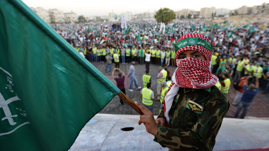 A boy holds a Muslim Brotherhood flag during a rally in support of Palestinians in Gaza, in Amman August 8, 2014. Israel launched its Gaza offensive on July 8 in response to a surge of rocket attacks by Gaza's dominant Hamas Islamists. Hamas said that Palestinians would continue confronting Israel until its blockade on Gaza was lifted. REUTERS/Muhammad Hamed (JORDAN - Tags: POLITICS CIVIL UNREST) - RTR41RA0