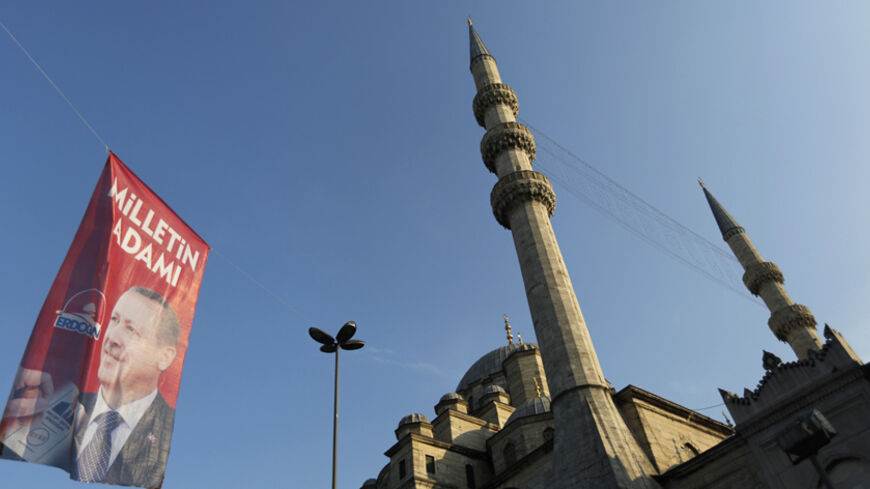 An election campaign banner of Turkey's Prime Minister and presidential candidate Tayyip Erdogan is seen near a mosque in Istanbul August 9, 2014. Erdogan is set to secure his place in history as Turkey's first popularly-elected president on Sunday, but his tightening grip on power has polarised the nation, worried Western allies and raised fears of creeping authoritarianism. REUTERS/Murad Sezer (TURKEY  - Tags: POLITICS ELECTIONS) - RTR41T1P