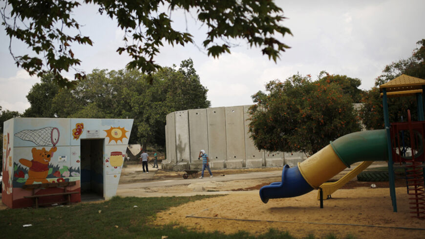 Labourers work near kindergarten surrounded by concrete blast walls, erected to protect against Palestinian rocket and mortar salvoes, on the first day of the school year in Kibbutz Nahal Oz, just outside the Gaza strip, September 1, 2014. An open-ended ceasefire in the Gaza war has held since August 27. Many families with small children from Nahal Oz have not returned to their homes yet as they fear the ceasefire will not hold. A four-year-old Israeli boy from Nahal Oz was killed by a mortar attack from Ga