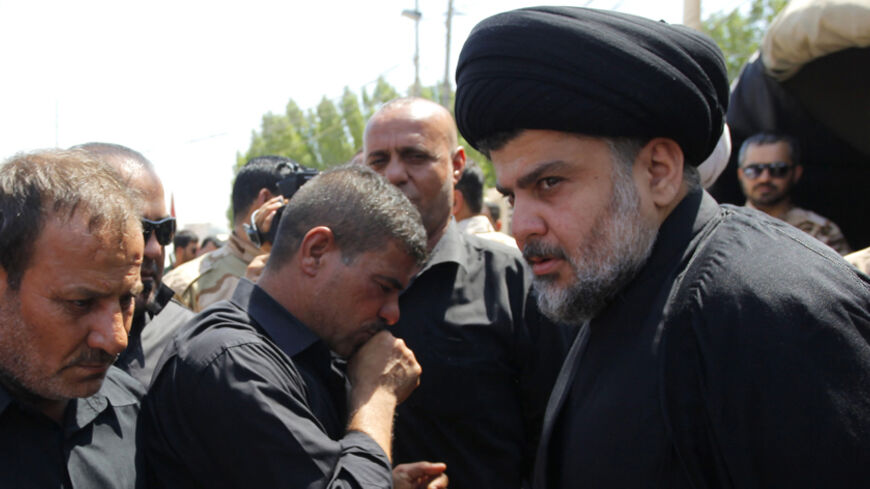 Radical Shi'ite cleric Muqtada al-Sadr (R) attends the funeral of fighters loyal to his Brigades of Peace, who were killed when an improvised explosive device (IED) exploded near the town of Amerli, in Najaf, south of Baghdad September 3, 2014. REUTERS/ Alaa Al-Marjani (IRAQ - Tags: CIVIL UNREST MILITARY POLITICS CONFLICT) - RTR44SOC
