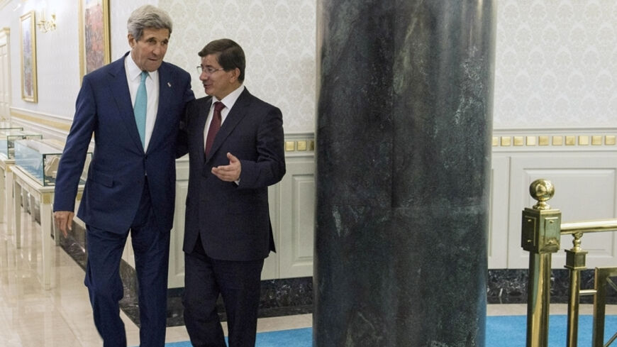 Turkey's Prime Minister Ahmet Davutoglu (R) walks with U.S. Secretary of State John Kerry at the prime minister's office in Ankara September 12, 2014. Kerry met Turkish leaders on Friday to try to win support for U.S.-led military action against Islamic State, but Ankara's reluctance to play a frontline role showed the difficulty of building a coalition for a regional war. REUTERS/Brendan Smialowski/Pool (TURKEY - Tags: POLITICS) - RTR460SV