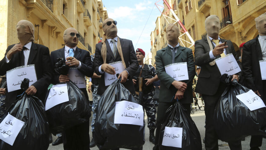 Lebanese activists dressed as politicians carry plastic bags with their heads covered in stockings during a demonstration against the extension of parliament, near the parliament building in downtown Beirut October 1, 2014. REUTERS/Sharif Karim  (LEBANON - Tags: POLITICS CIVIL UNREST) - RTR48HVC
