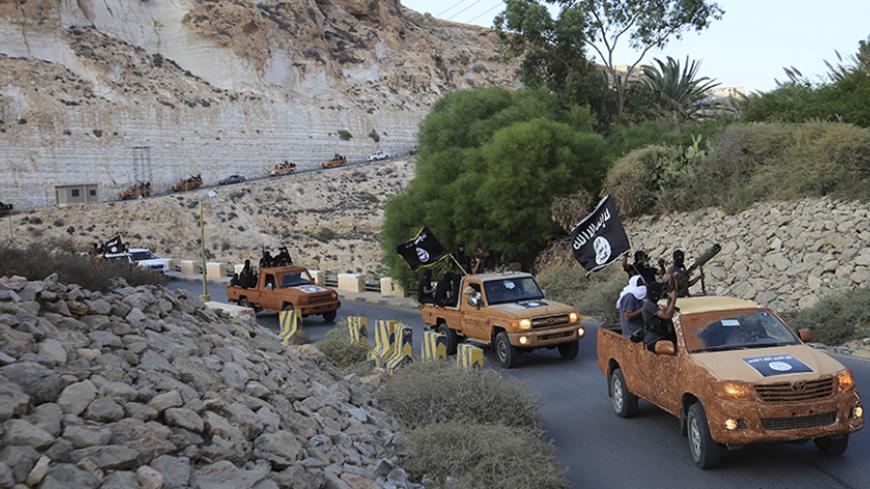 An armed motorcade belonging to members of Derna's Islamic Youth Council, consisting of former members of militias from the town of Derna, drive along a road in Derna, eastern Libya October 3, 2014. The group pledged allegiance to the Islamic State on October 3, 2014 local media reported. Picture taken October 3, 2014. REUTERS/Stringer (LIBYA - Tags: POLITICS CIVIL UNREST CONFLICT TPX IMAGES OF THE DAY) - RTR49BS8