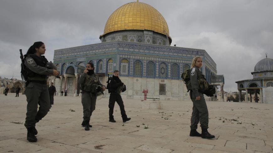 Israeli border police officers walks in front of the Dome of the Rock on the compound known to Muslims as Noble Sanctuary and to Jews as Temple Mount in Jerusalem's Old City November 5, 2014. Israeli security forces hurling stun grenades clashed with Palestinian stone-throwers at al-Aqsa mosque - a confrontation that has played out frequently over the past several weeks. REUTERS/Ammar Awad (JERUSALEM - Tags: POLITICS CIVIL UNREST RELIGION) - RTR4CY31
