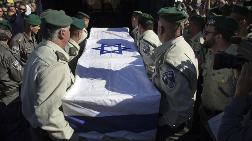 Israeli border police officers lift the flag-draped coffin of their comrade Jedan Assad during his funeral in the Druze village of Beit Jann in Israel's Galilee November 6, 2014. On Wednesday, a Palestinian man rammed his vehicle into pedestrians and Israeli border police on a road straddling East and West Jerusalem, killing Assad and wounding a dozen. The attacker was shot dead by police. REUTERS/Finbarr O'Reilly (ISRAEL - Tags: POLITICS CIVIL UNREST OBITUARY) - RTR4D442