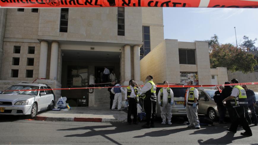 Members of the Israeli Zaka emergency response team stand at the scene of an attack at a Jerusalem synagogue November 18, 2014. Two suspected Palestinian men armed with axes and knives killed four people in a Jerusalem synagogue on Tuesday before being shot dead by police, Israeli police and emergency services said, the deadliest such attack in the city in years. REUTERS/Ammar Awad (JERUSALEM - Tags: CIVIL UNREST POLITICS RELIGION) - RTR4EJEF