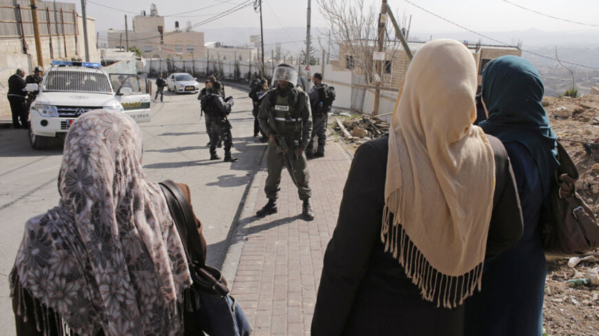 Palestinian women stand in front of Israeli border police officers in the Jerusalem district of Jabal Mukaber November 18, 2014. Two Palestinians, Ghassan and Udai Abu Jamal, cousins from Jabal Mukaber, armed with a meat cleaver and a gun killed four worshippers in a Jerusalem synagogue on Tuesday before being shot dead by police, the deadliest such incident in six years in the holy city amid a surge in religious conflict. REUTERS/Ammar Awad (JERUSALEM - Tags: CIVIL UNREST POLITICS MILITARY) - RTR4EL5A