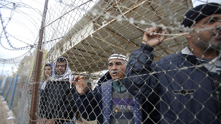 Palestinians stand behind a fence as they wait for their relatives to return to Gaza at the Rafah border crossing between Egypt and southern Gaza Strip November 27, 2014. Egypt opened the Rafah border crossing on Wednesday to allow thousands of stranded Palestinians to return to Gaza but the frontier will remain closed to traffic going the other way, Palestinian and Egyptian border officials said.  REUTERS/Ibraheem Abu Mustafa (GAZA - Tags: POLITICS SOCIETY IMMIGRATION TPX IMAGES OF THE DAY) - RTR4FSZM