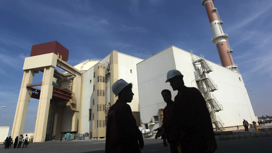 Iranian workers stand in front of the Bushehr nuclear power plant, about 1,200 km (746 miles) south of Tehran October 26, 2010. Iran has begun loading fuel into the core of its first nuclear power plant on Tuesday, one of the last steps to realising its stated goal of becoming a peaceful nuclear power, state-run Press TV reported on Tuesday. REUTERS/Mehr News Agency/Majid Asgaripour (IRAN - Tags: POLITICS ENERGY IMAGES OF THE DAY) - RTXTUI4