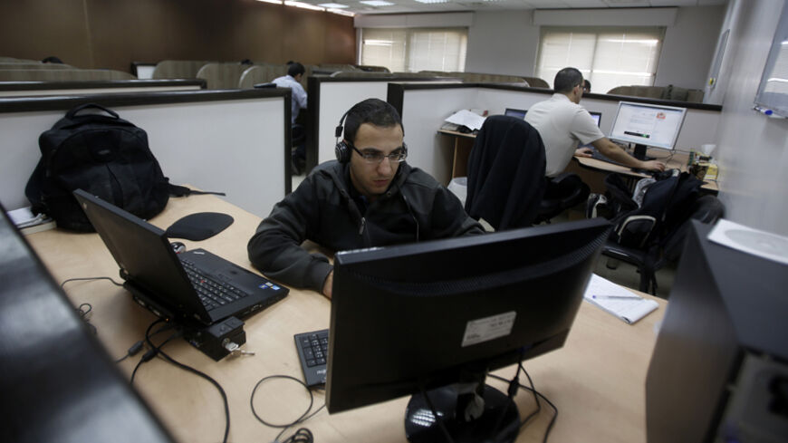 Employees work on computers at Exalt Technologies, a company which deals in research and development outsourcing from Cisco and French-American group Lucent-Alcatel, in the West Bank city of Ramallah April 7, 2013. Fledgling Palestinian high-tech firms hope they can now help revitalise the economy, making the West Bank more resistant to Israeli controls on land and the movement of goods and people and less dependent on fickle foreign aid flows, which are blighting the public sector. Picture taken April 7, 2