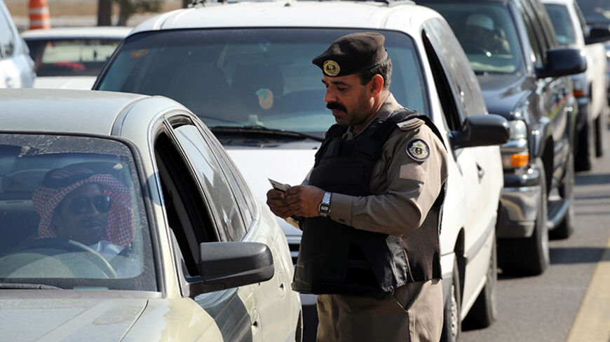 A Saudi policeman checks the ID card of a driver at a checkpoint in the mostly Shiite Qatif region of Eastern Province on November 25, 2011. Four people have been killed and nine others wounded in an exchange of gunfire between security forces and what the Saudi interior ministry called criminals serving a foreign power in the country's oil-producing Eastern Province. AFP PHOTO/FAYEZ NURELDINE (Photo credit should read FAYEZ NURELDINE/AFP/Getty Images)