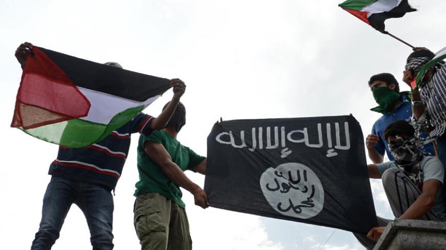 Kashmiri demonstrators hold up Palestinian flags and a flag of the Islamic State of Iraq and the Levant (ISIL) during a demonstration against Israeli military operations in Gaza, in downtown Srinagar on July 18, 2014. The death toll in Gaza hit 265 as Israel pressed a ground offensive on the 11th day of an assault aimed at stamping out rocket fire, medics said. AFP PHOTO/Tauseef MUSTAFA        (Photo credit should read TAUSEEF MUSTAFA/AFP/Getty Images)