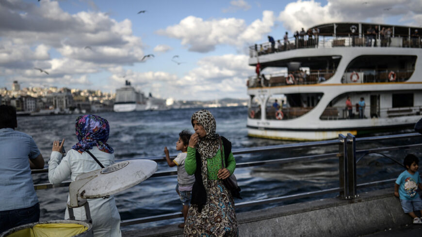 A Syrian woman (C) stands with her daughter near the Bosphorus on August 30, 2014, at Eminonu, in Istanbul. AFP PHOTO/BULENT KILIC        (Photo credit should read BULENT KILIC/AFP/Getty Images)