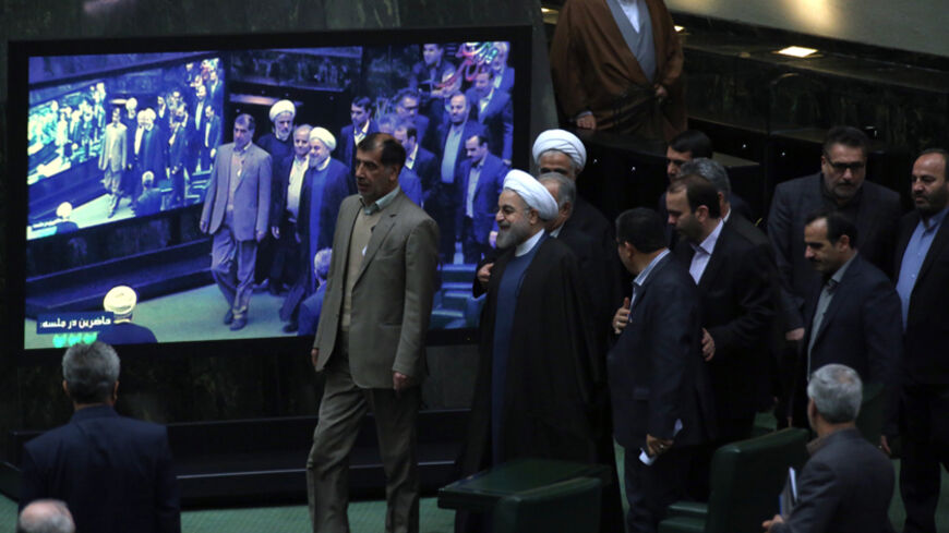 Iranian President Hassan Rouhani (C) arrives at parliament before presenting the proposed annual budget in Tehran on December 7, 2014. Iran's parliament has adopted a law on December 4, to tax religious foundations and military-linked companies, a first for the Islamic republic that could generate hundreds of millions of dollars in revenues, media reported. AFP PHOTO/ATTA KENARE        (Photo credit should read ATTA KENARE/AFP/Getty Images)