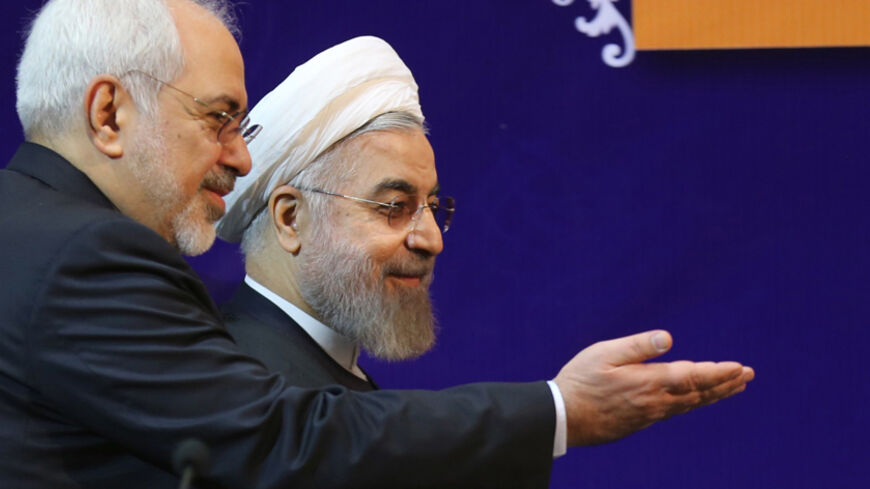 Iranian President Hassan Rouhani (R) arrives with the Islamic republic's Foreign Minister Mohammad Javad Zarif at the opening session of a two-day conference on combatting extremism on December 9, 2014 in Tehran. Delegations from 40 countries, including Syria and Iraq, are attending the meetings. AFP PHOTO/ATTA KENARE        (Photo credit should read ATTA KENARE/AFP/Getty Images)