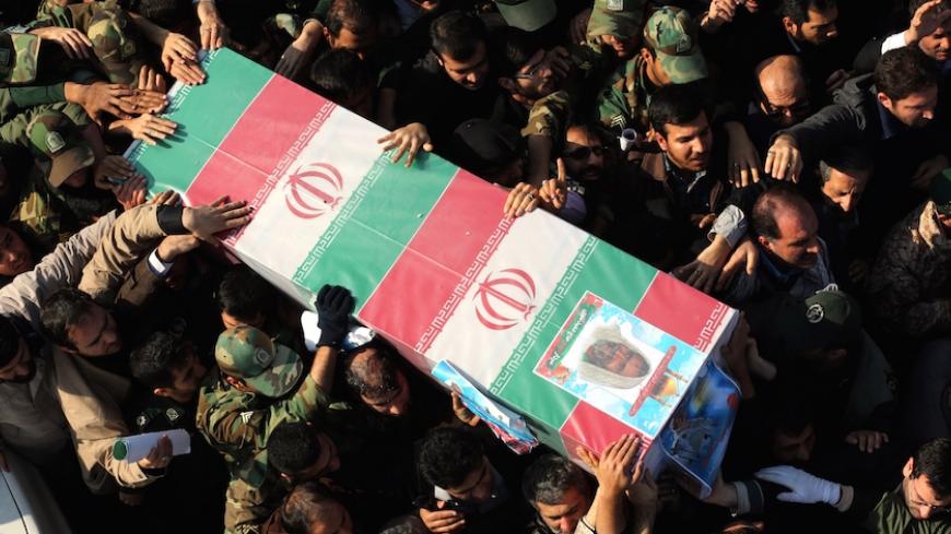 Iranians carry the coffin of Brigadier General Hamid Taghavi, a commander of the Revolutionary Guards reportedly killed in the Iraqi city of Samarra, during his funeral in the capital Tehran on December 29, 2014. According to Iran's Revolutionary Guards, the senior military officer has been killed while advising Iraqi troops in their fight against the Islamic State group. AFP PHOTO / ATTA KENARE        (Photo credit should read ATTA KENARE/AFP/Getty Images)