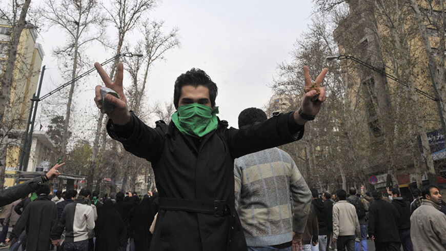 EDITORS' NOTE: Reuters and other foreign media are subject to Iranian restrictions on their ability to film or take pictures in Tehran.

An Iranian protestor with his face covered with a green mask flashes the victory sign as he holds stones in his hands during clashes in central Tehran December 27, 2009. A senior Iranian police official denied a report on an opposition website that four pro-reform protesters were killed during clashes in Tehran on Sunday, the Students News Agency ISNA reported. REUTERS/Str